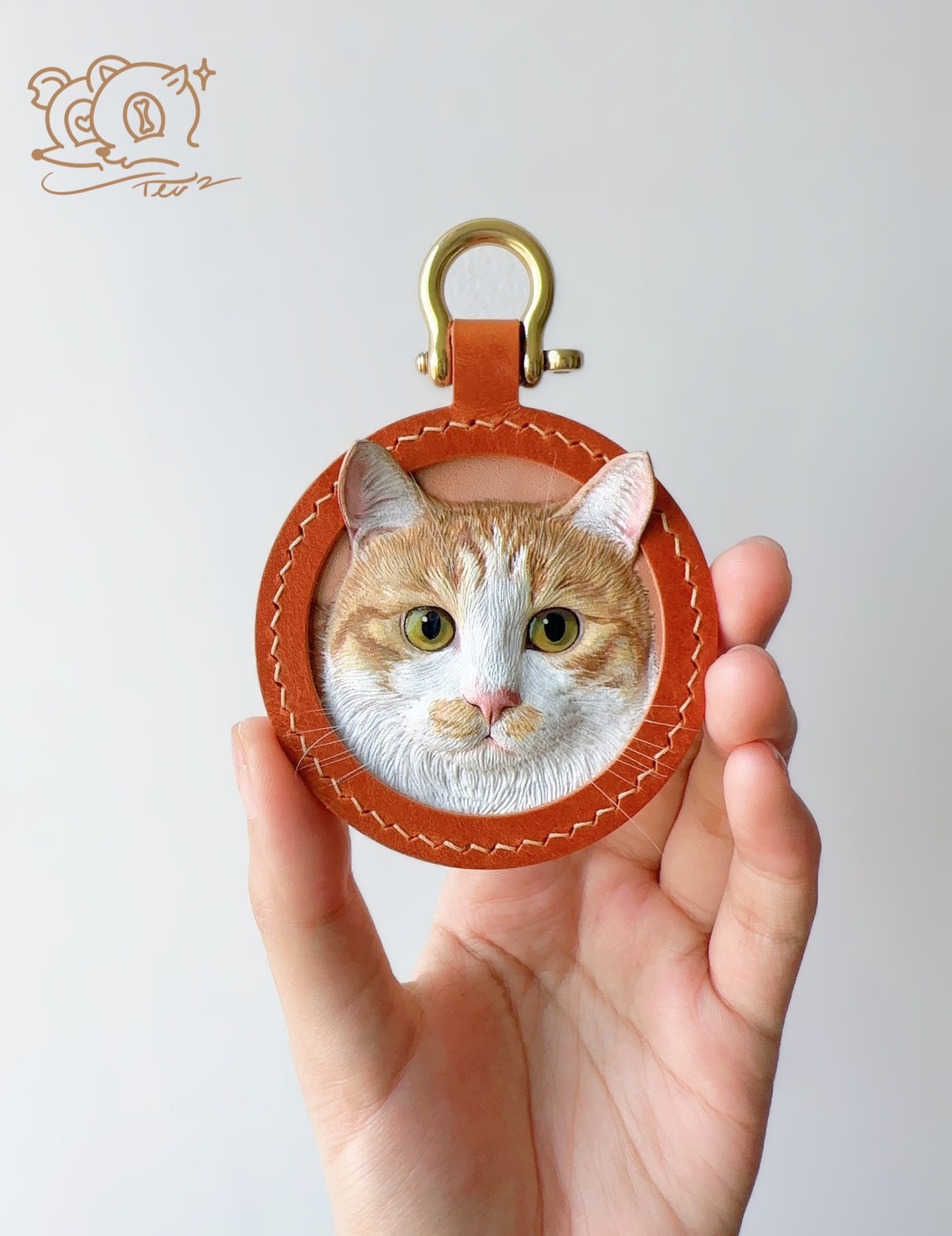 A handmade circular leather portrait held in the artist's hand